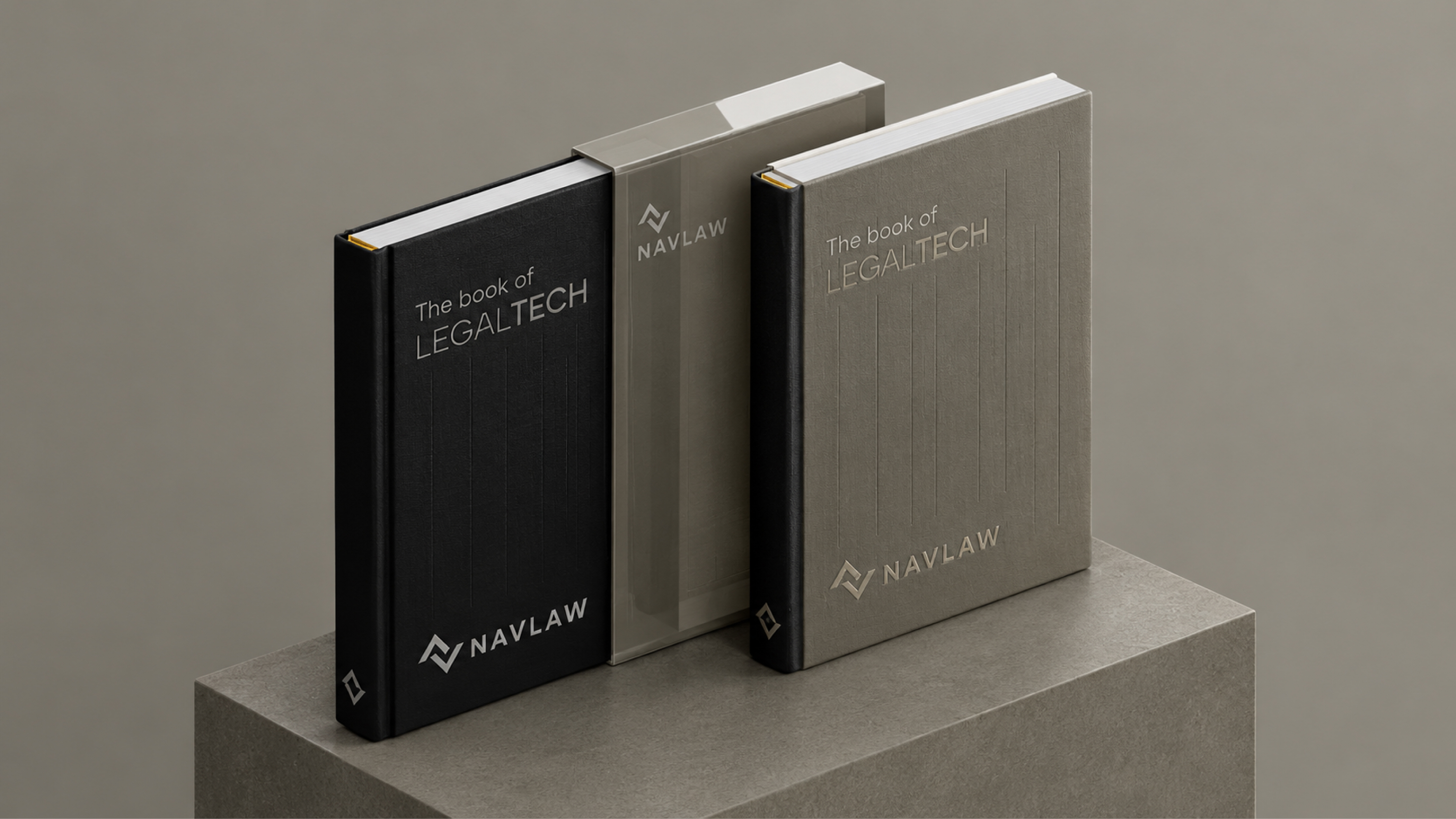 NAVLAW branded publications — "The book of LEGALTECH" in Dark Grey and Soft Gold hardcover editions with debossed NAVLAW logomark, displayed on a concrete presentation plinth against warm grey background